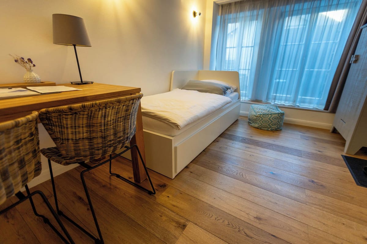 A compact room with a bed, a desk, and a chair.