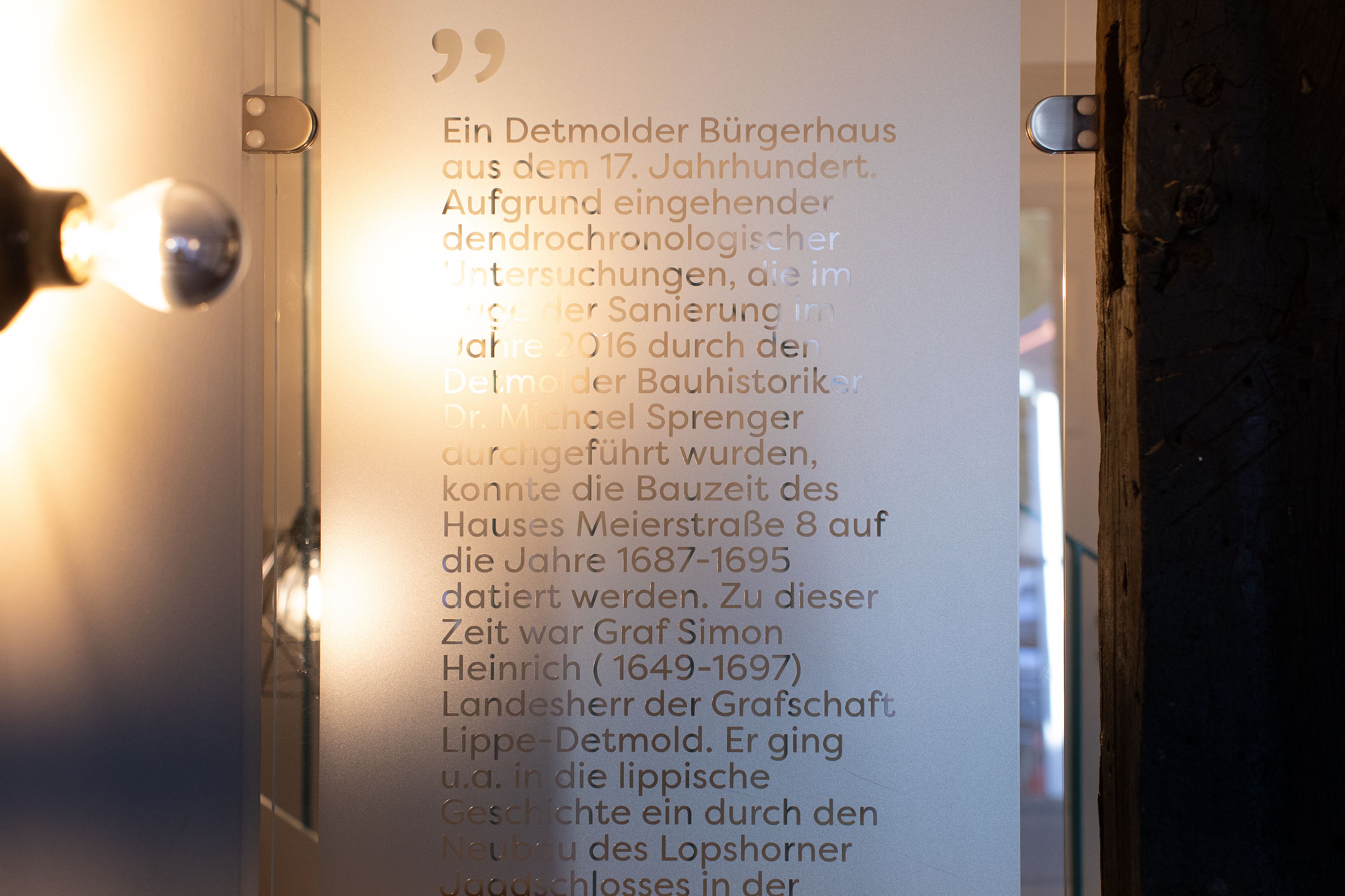 A wall with a quote in German about a Detmolder Bürgerhaus from the 17th century.
