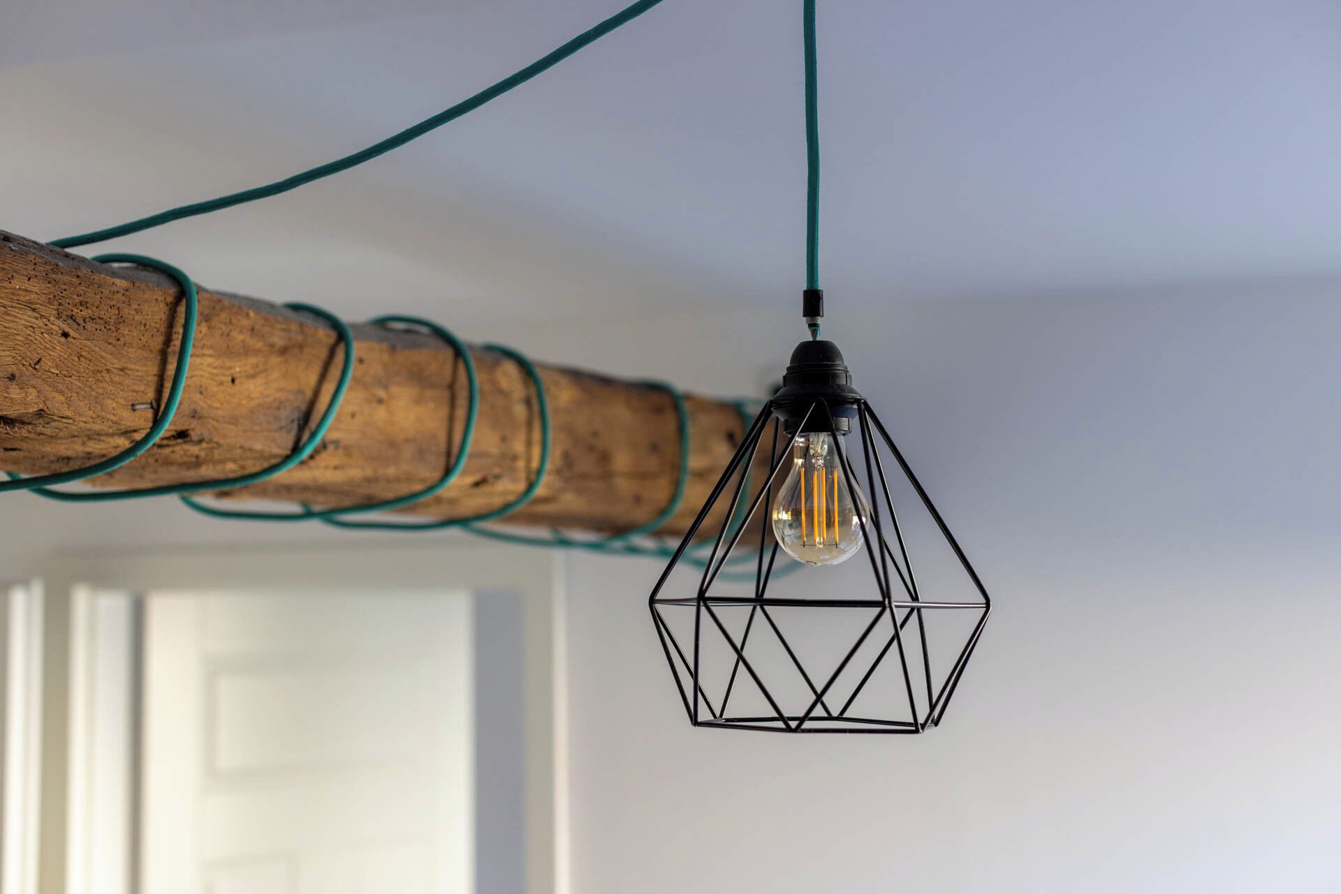 Een hanglamp met een geometrisch ontwerp en een zichtbare lamp.