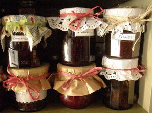 A collection of jars with labels and ribbons, likely containing preserved food items. - Maison d'hôtes La Cour des Lauriers (Saint-Hippolyte-de-Montaigu)