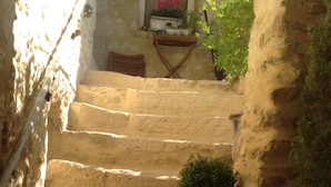 A stone staircase with a potted plant and a lantern at the bottom. - Maison d'hôtes La Cour des Lauriers (Saint-Hippolyte-de-Montaigu)