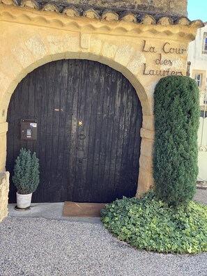 A large wooden door with a sign above it reading "La Cour des Lauriers". - Maison d'hôtes La Cour des Lauriers (Saint-Hippolyte-de-Montaigu)