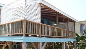 A wooden deck with a railing, supported by wooden beams. - Carolyns Other House (Caye Caulker)