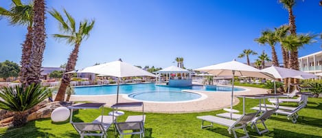 Een seizoensgebonden buitenzwembad, parasols voor strand/zwembad