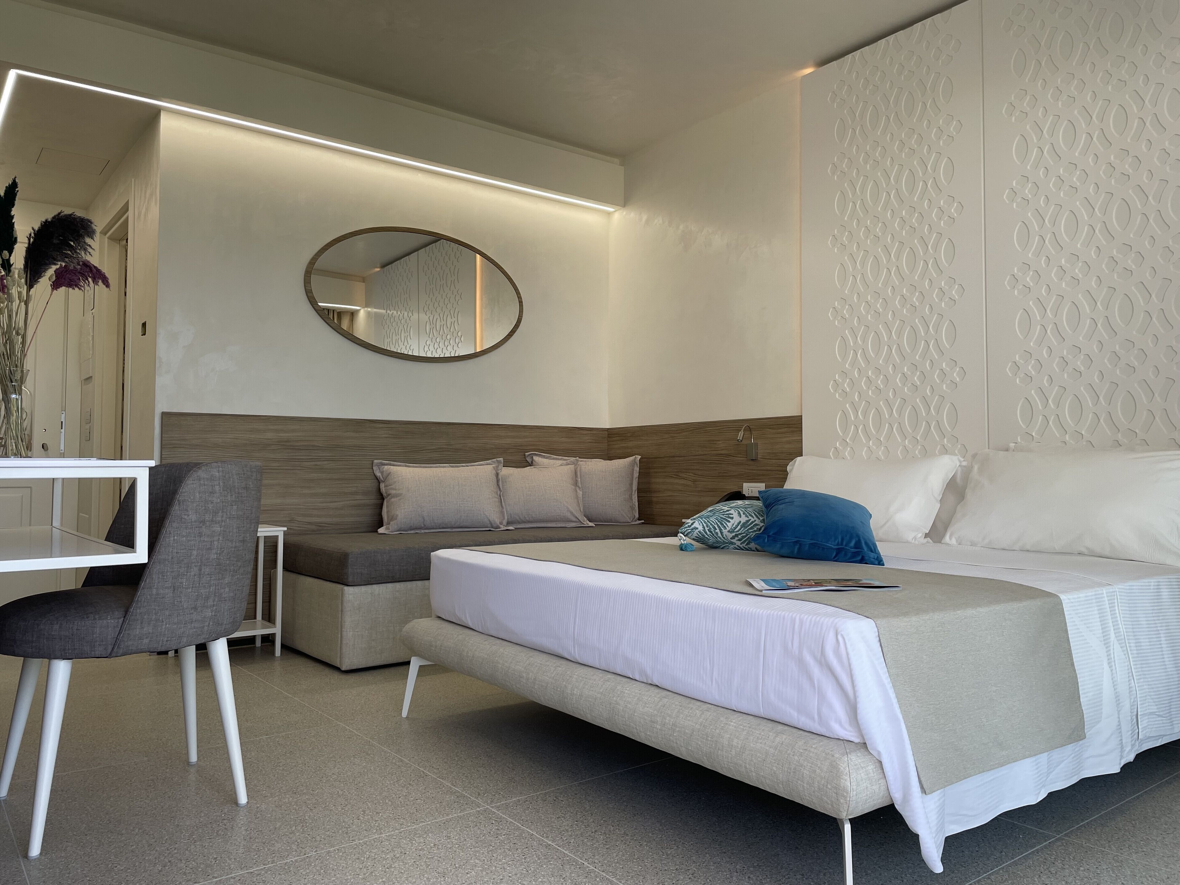 Una camera d'albergo moderna con un letto, una scrivania e una sedia.