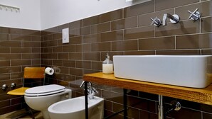 A modern bathroom with a large white sink, two toilets, and a wooden vanity. - Palazzo Bevilacqua Napoli B&B (Naples)