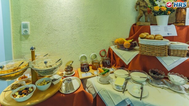 A buffet table with various food items and utensils. - Kurhotel Emilie (Bad Woerishofen)