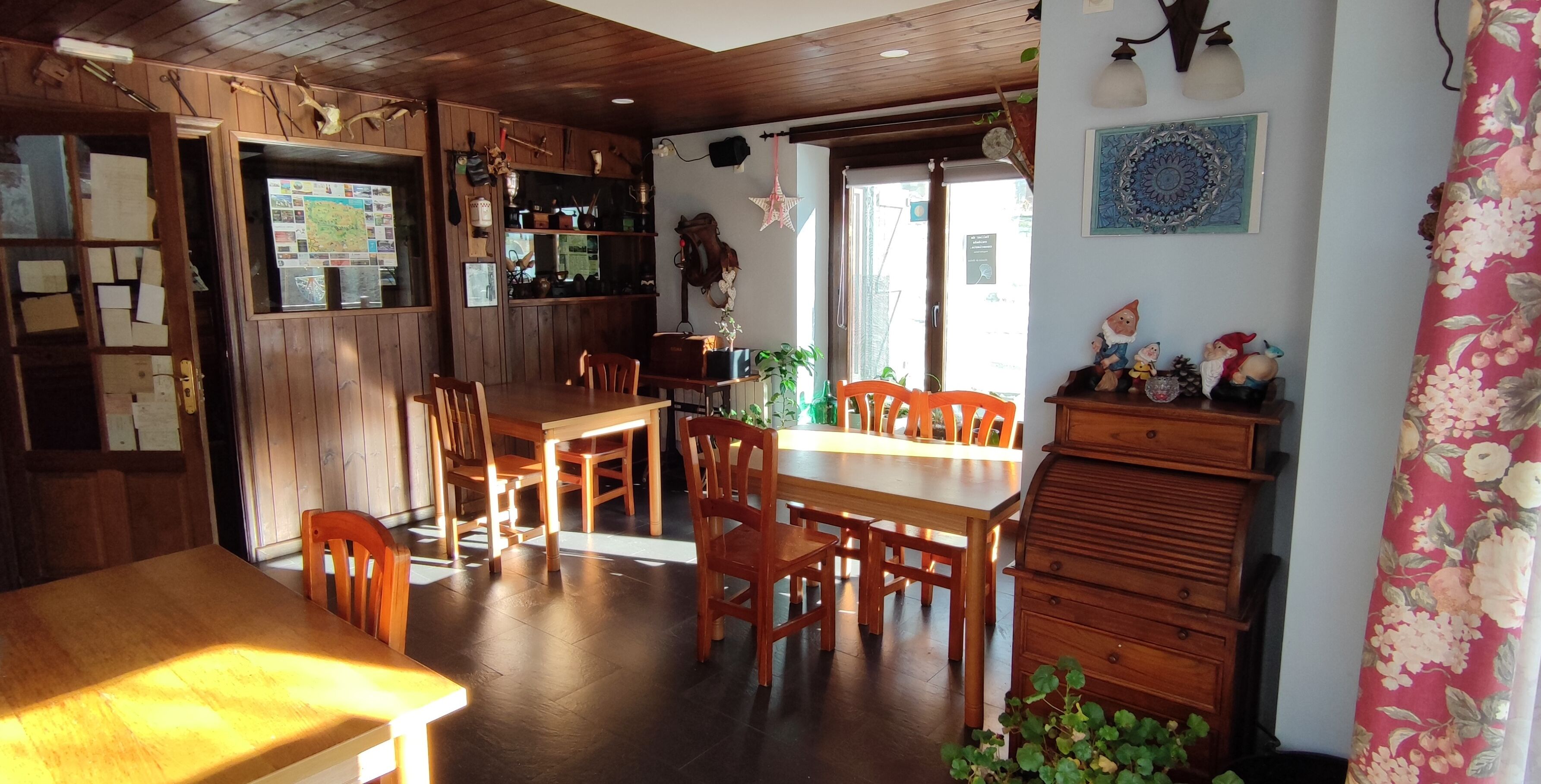 A cozy dining area with wooden furniture, a map on the wall, and a decorative cabinet.