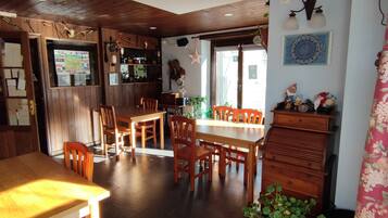 A cozy dining area with wooden furniture, a map on the wall, and a decorative cabinet.