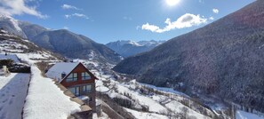 A mountain cabin with a wooden exterior and large windows, surrounded by snow-covered landscapes and mountains. - Hotelet de Betlan (Vielha e Mijaran)