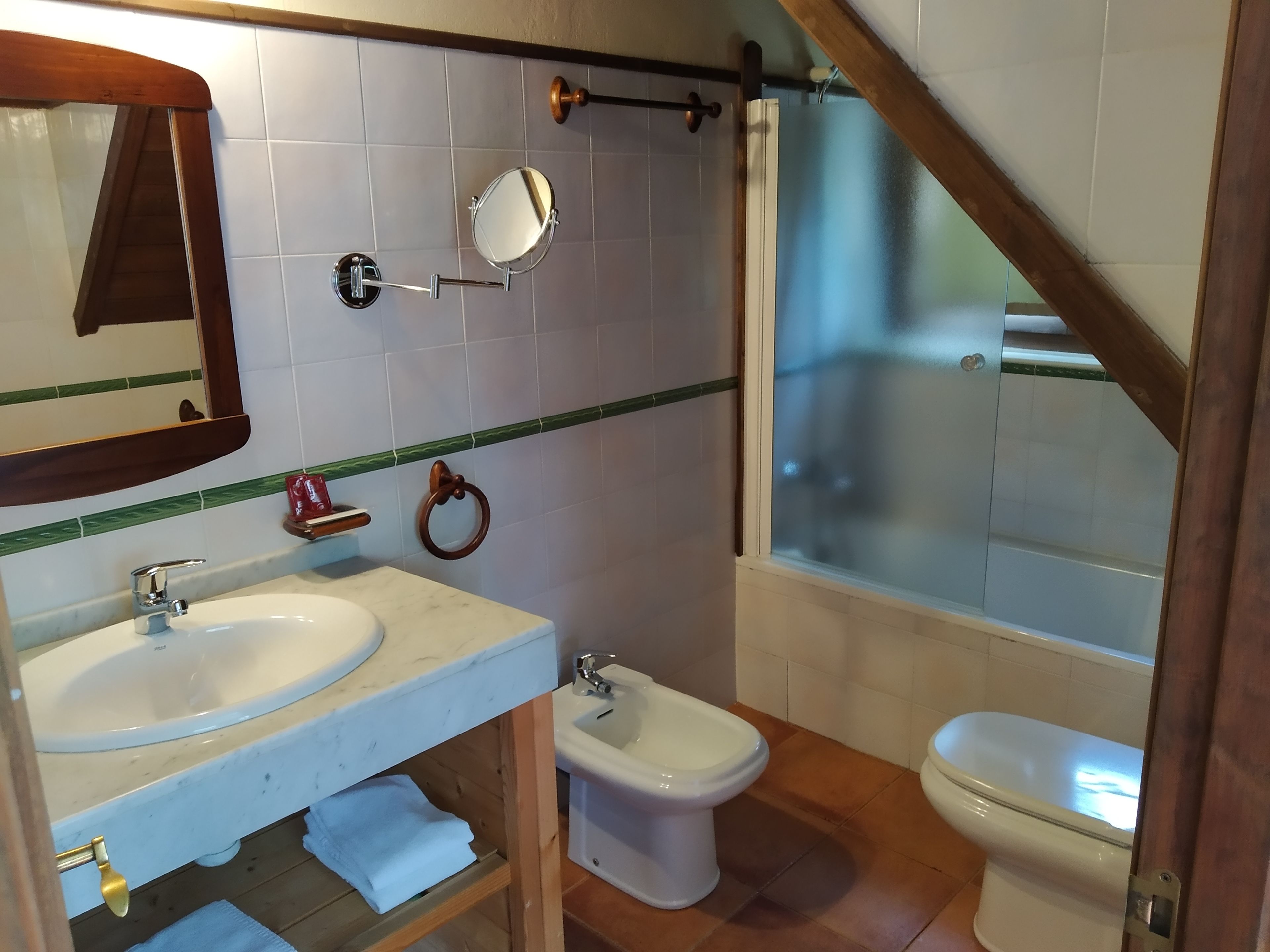 Un baño con lavabo, bidé, inodoro y espejo.