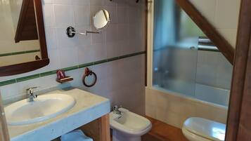 Un baño con lavabo, bidé, inodoro y espejo.