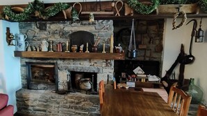 Una habitación acogedora con chimenea de piedra, repisa de madera y varios objetos decorativos.