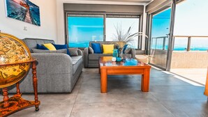 Un salon moderne avec un canapé gris, une table basse en bois et un globe terrestre posé sur un pied.