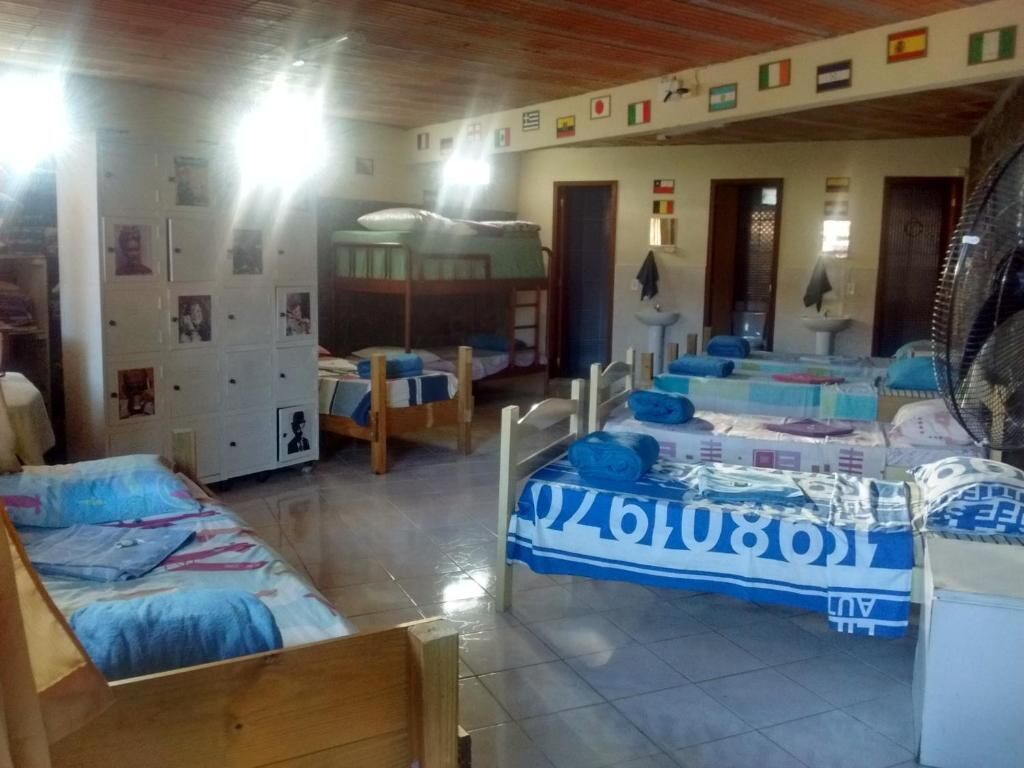 A dormitory room with bunk beds, a small kitchenette, and a tiled floor.