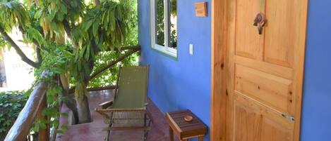 A room with a wooden door, a bench, and a chair.