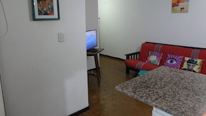 A living room with a red sofa, a television, and a framed picture on the wall. - Beautiful Quiet Apartment Near Aristides (Mendoza)