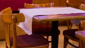 A restaurant interior with wooden furniture, a red tablecloth, and a white table. - Palace Hotel Mendoza (Mendoza)
