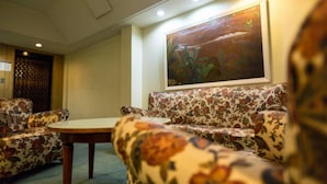 A room with floral-patterned sofas and a round table. - Palace Hotel Mendoza (Mendoza)