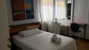 A hotel room with a bed, a desk, a chair, a coffee maker, and a painting on the wall. - Palace Hotel Mendoza (Mendoza)