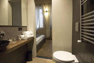 A compact bathroom with a sink, mirror, and towel rack.