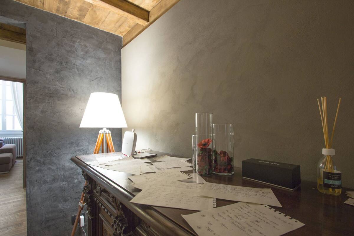A desk with papers, a lamp, a speaker, and a box labeled 'CANNELL'.