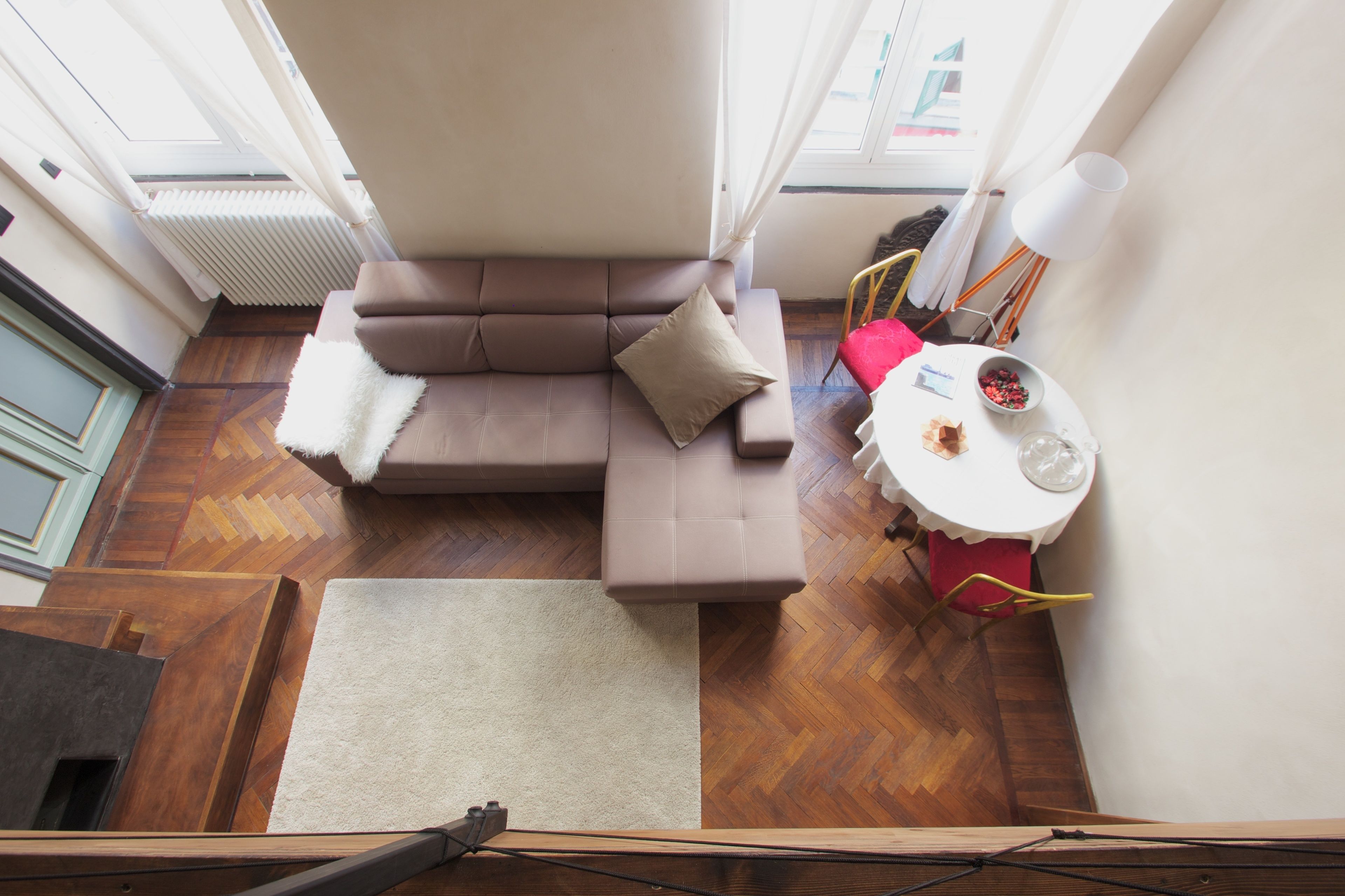 A compact living space with a sofa, a small table with a bowl of fruit, and a radiator.