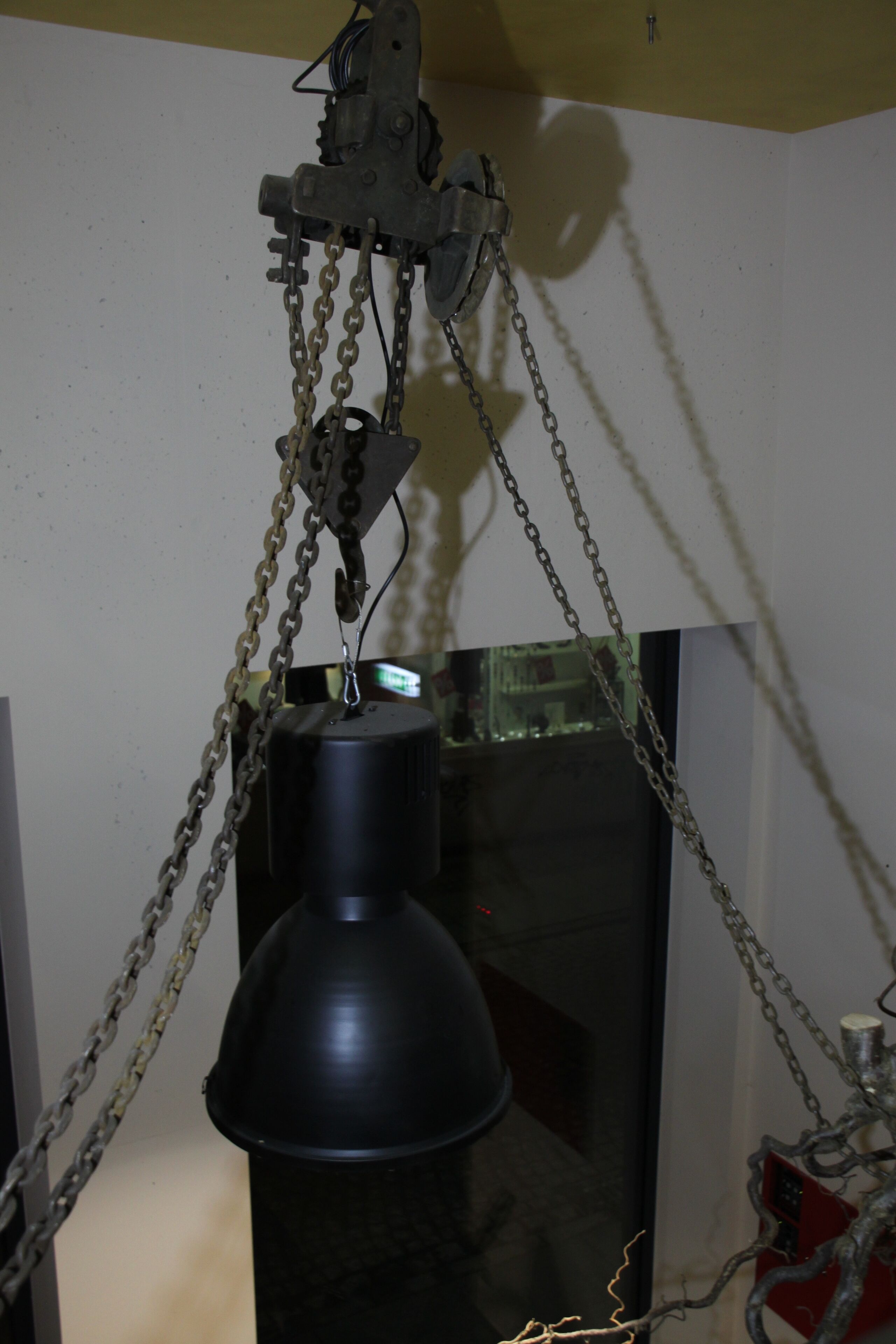 Un elevador mecánico con cadenas y motor, probablemente utilizado para mover objetos pesados.