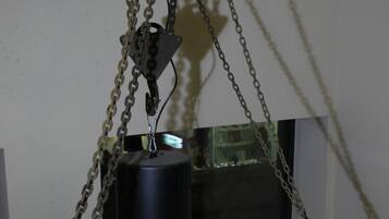Un elevador mecánico con cadenas y motor, probablemente utilizado para mover objetos pesados.