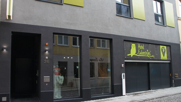 Un hotel con fachada moderna, amplias ventanas y un cartel que indica que es el Hotel Eulensteins.