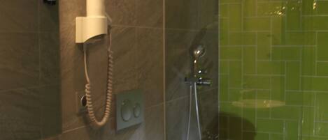 Un bagno con lavandino, specchio e doccia rivestita in piastrelle verdi.