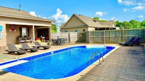 A swimming pool with lounge chairs and a covered patio area. - Southern Backroad Retreats (The Pool House) (Goshen)