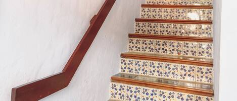 Una escalera con baldosas estampadas y barandillas de madera.