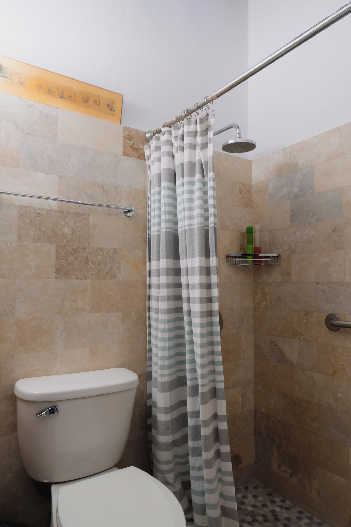 Une salle de bain équipée de toilettes, d’une douche et d’un porte-serviettes.