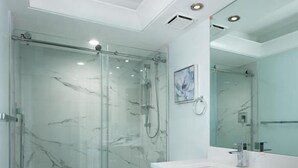 A modern bathroom with a glass-enclosed shower, a toilet, and a vanity with a large mirror. - Beachfront 2BR/2BA Marco Island condo with pool, WiFi, and beach access. (Marco Island)