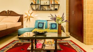 Un salon bien éclairé, avec un canapé, une table basse en verre et une bibliothèque.