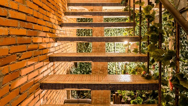 Un escalier en briques avec un sol carrelé menant à un niveau inférieur.