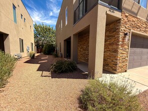 A modern building with a stone facade, a garage, and a gravel driveway. - Entrada at Moab - 424b, Spacious 4 Bed 3 Bath House (Moab)