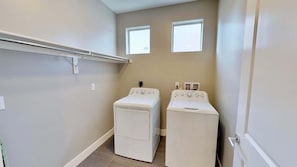 A laundry room with two white washing machines, a metal drying rack, and two windows providing natural light. - Entrada at Moab - 424b, Spacious 4 Bed 3 Bath House (Moab)
