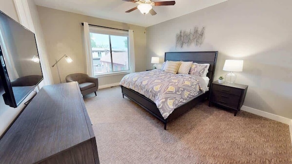 A bedroom with a bed, bedside tables, a desk, a chair, a ceiling fan, and a window. - Entrada at Moab - 424b, Spacious 4 Bed 3 Bath House (Moab)