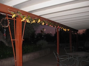 An outdoor patio area with a pergola structure, metal chairs, and tables. - Desert Adobe 5-acre Crystal Ranch (Tucson)
