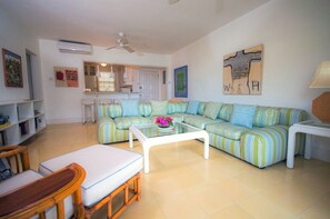 A living room with a sofa, a coffee table, and a dining area. - Superb 2 Bedroom/2 Bath Beachfront Condo in Tower Isle, near Ocho Rios (Tower Isle)