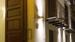 A narrow street with a wooden door and a metal railing on a building. - Moncada Houses at Quattro Canti (Palermo)