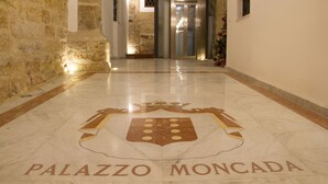 A marble floor with a coat of arms and the words "PALAZZO MONCADA" in a hallway. - Moncada Houses at Quattro Canti (Palermo)