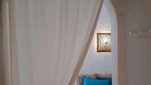 A room with a bed, a window, and a curtain.