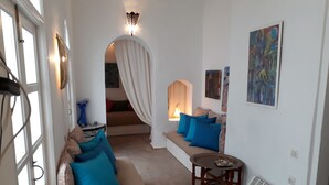 A cozy living room with a sofa, a small table, and a decorative lamp.