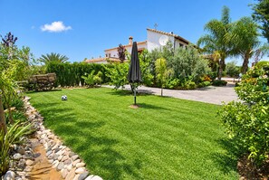 A well-maintained lawn with a patio area, a wooden cart, and a variety of plants and trees. - Cubo's Casa La Viña / private pool / air conditioning / free wifi (Alhaurín el Grande)