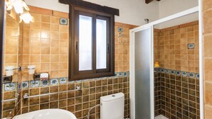 Une salle de bain avec des toilettes, un lavabo et une douche.