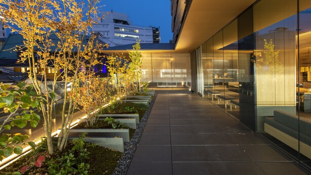 A modern building with a glass facade, outdoor seating area, and well-maintained landscaping. - Tokyu Stay Kyoto Sakaiza Shijo-Kawaramachi (Kyoto)