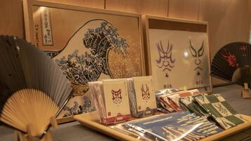 A display of Japanese art and fans, including a framed wave painting and a fan with a checkered pattern.